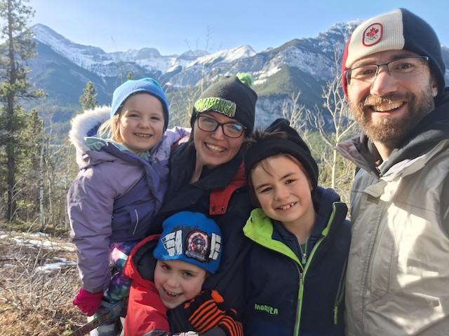 Family smiling in the Rockies near Calgary after their move